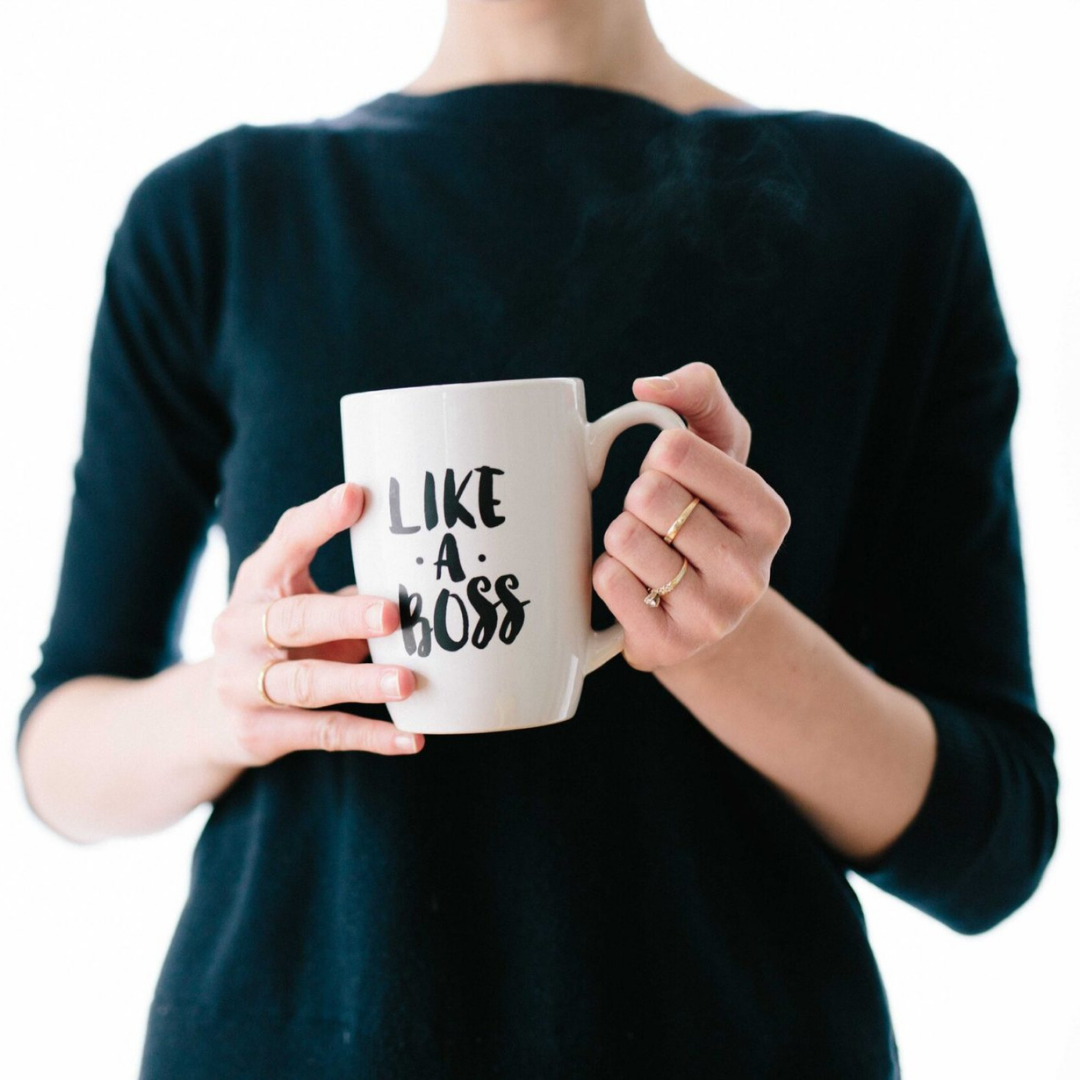 Image of a woman holding a coffee cup that says, "Like a Boss" which is how you'll feel when you book a motivational speaker